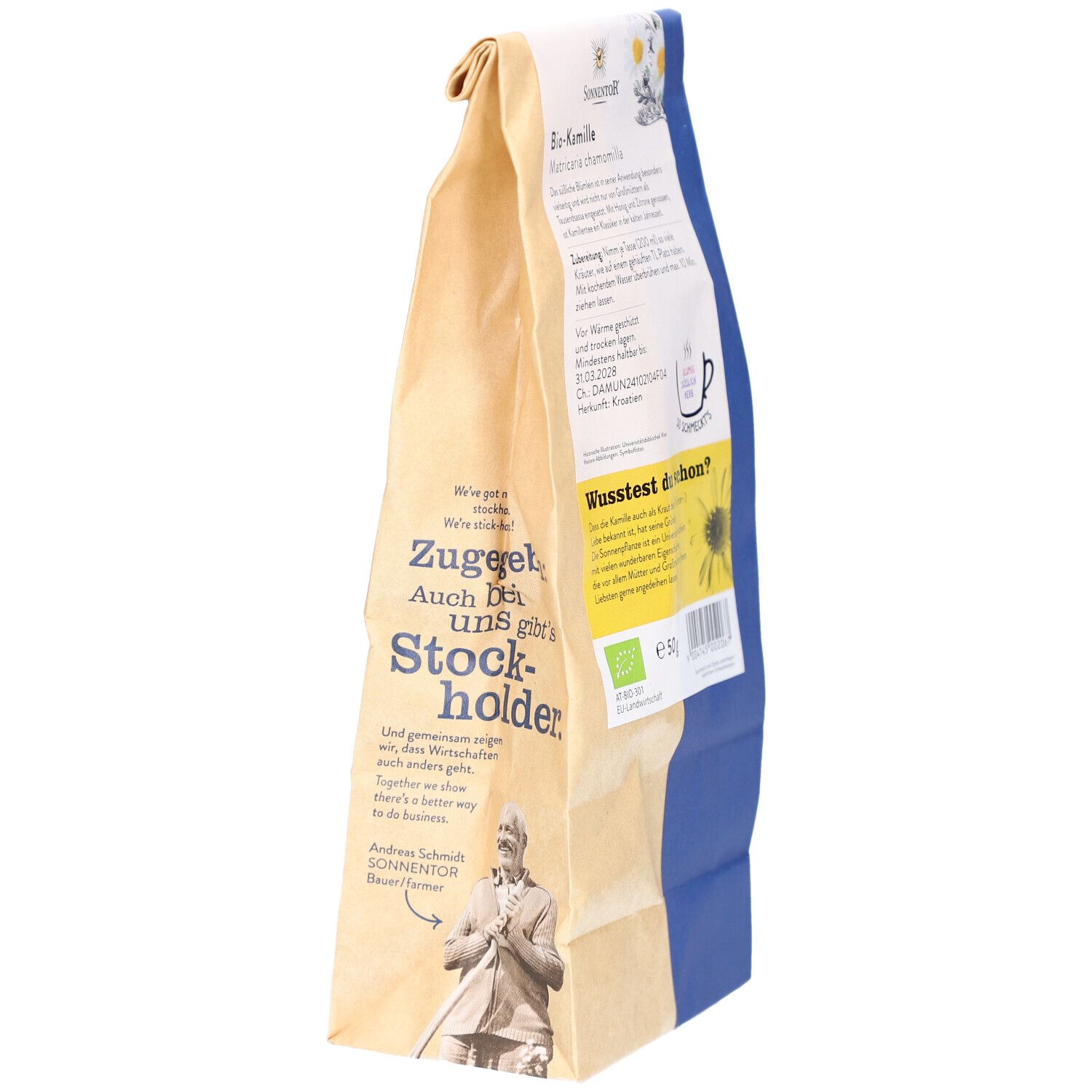 Rückseite eines Papierbeutels mit Kamillenblüten. Sichtbar: Text, Bio-Siegel, QR-Code, Illustration einer Person.