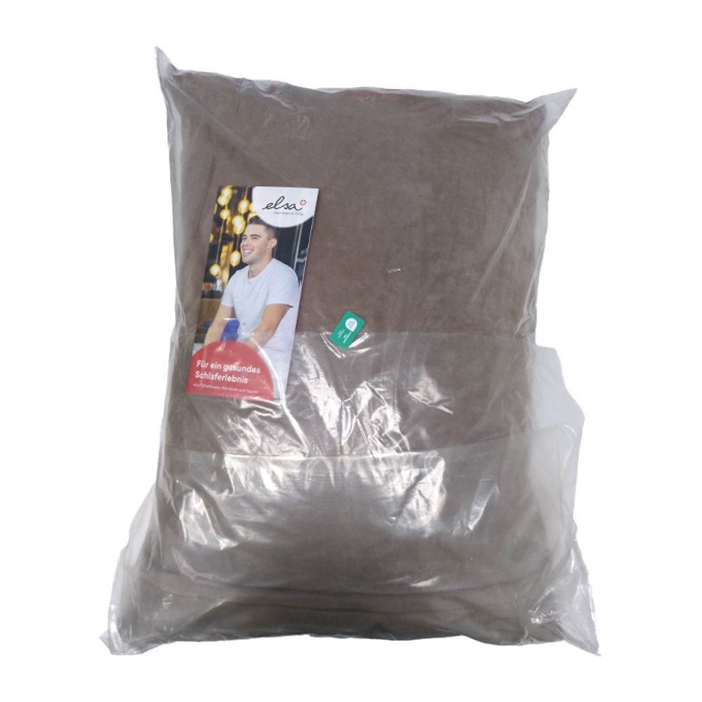 Kissen in transparenter Verpackung. Aufkleber mit Logo und Abbildung eines Mannes. Text auf Deutsch.