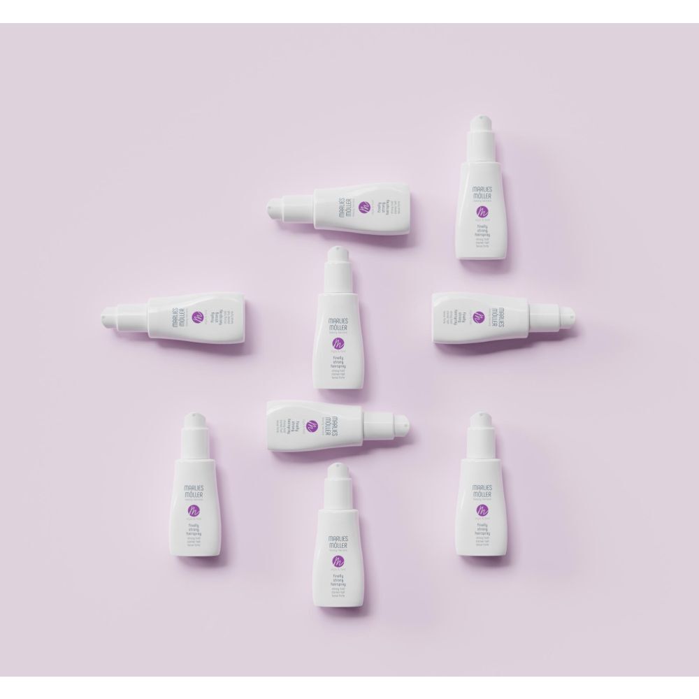 Plusieurs flacons de laque sur fond violet. Logo Marlies Möller et nom du produit.