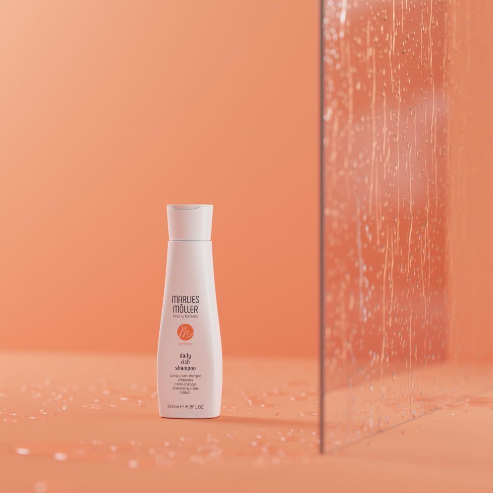 Flacon blanc Marlies Möller Daily Rich Shampoo sur fond orange. Logo orange. Flacon avec bouchon blanc.