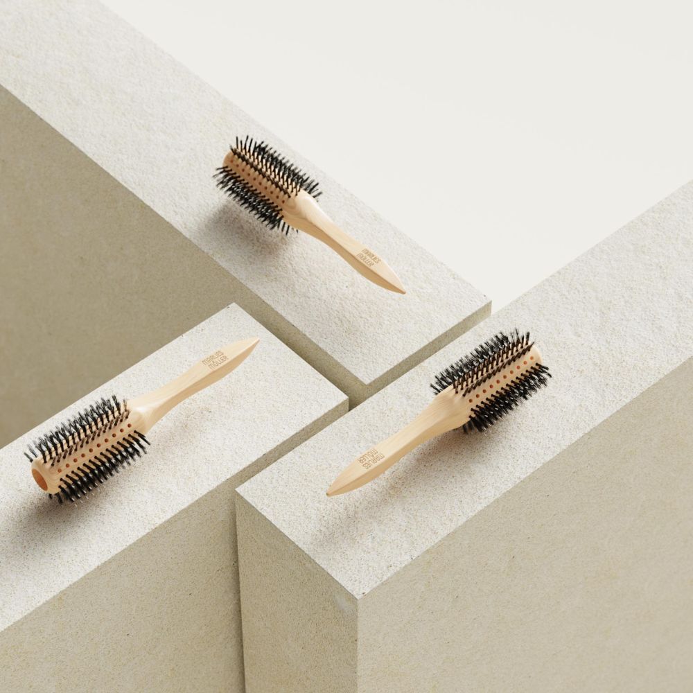 Trois brosses à cheveux rondes sur blocs blancs. Manche en bois, soies noires.