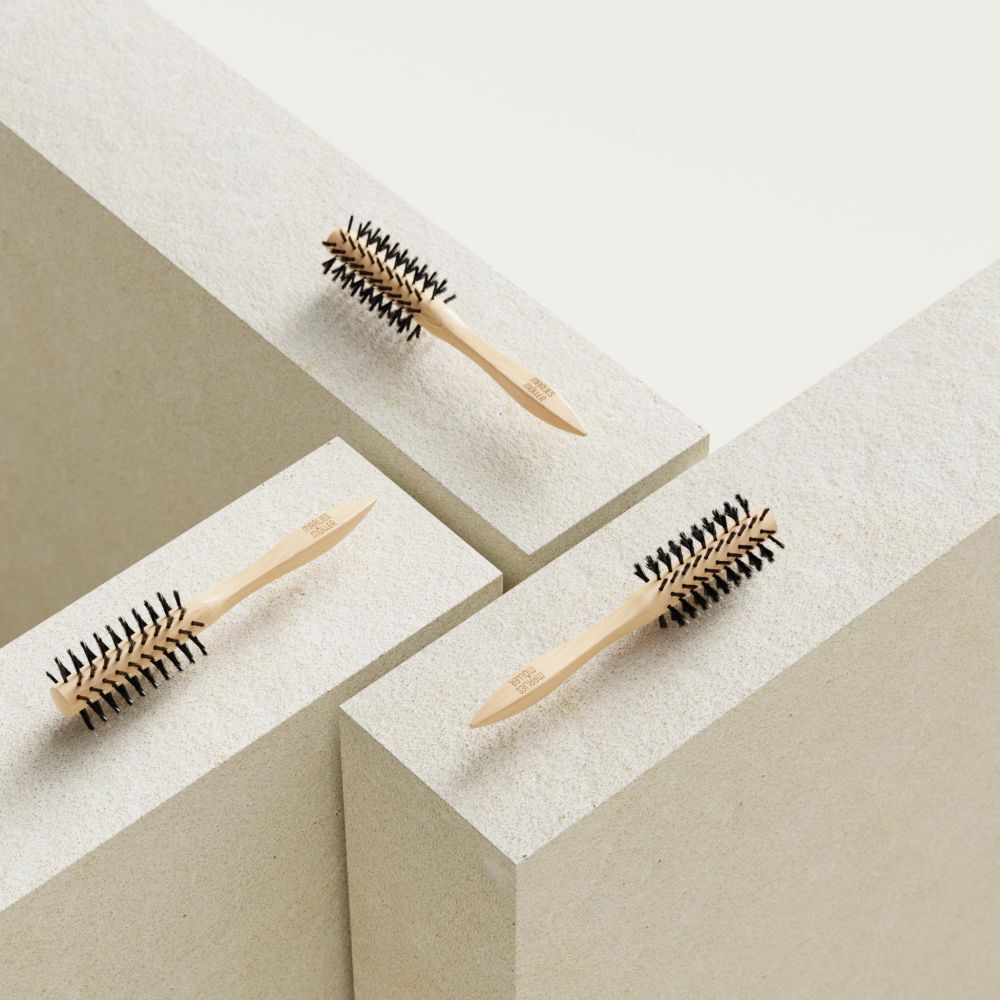 Trois brosses à coiffer sur blocs blancs. Manche en bois, poils noirs. MARLIES MÖLLER.