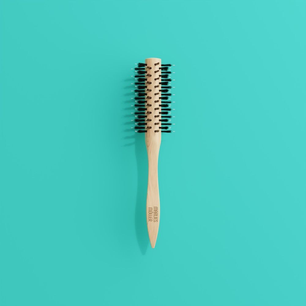 Brosse à coiffer sur fond turquoise. Manche en bois, poils noirs. MARLIES MÖLLER.