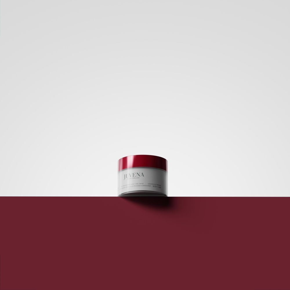 Pot de crème à couvercle rouge sur fond rouge. Inscription: Juvena. Nom du produit illisible.