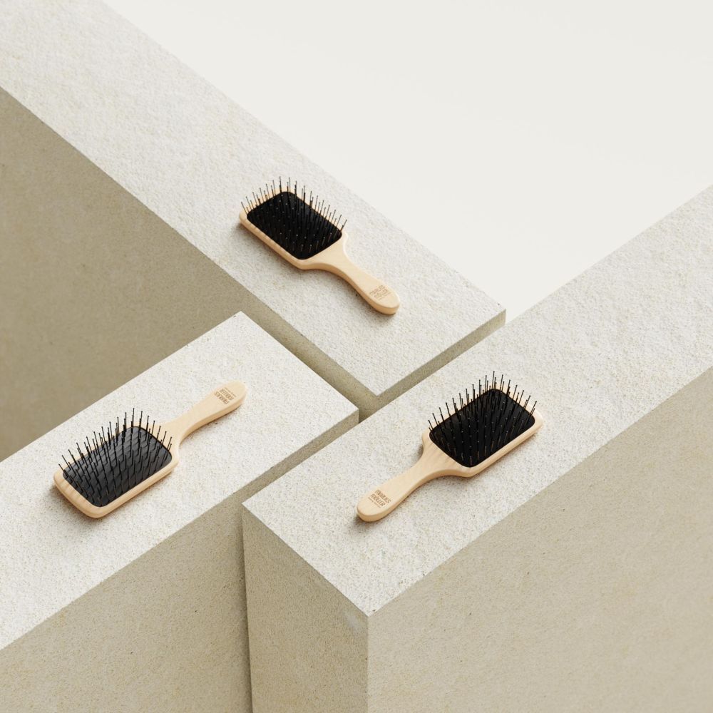 Trois brosses à cheveux sur blocs blancs. Manche en bois, coussin noir. Marque Marlies Möller.
