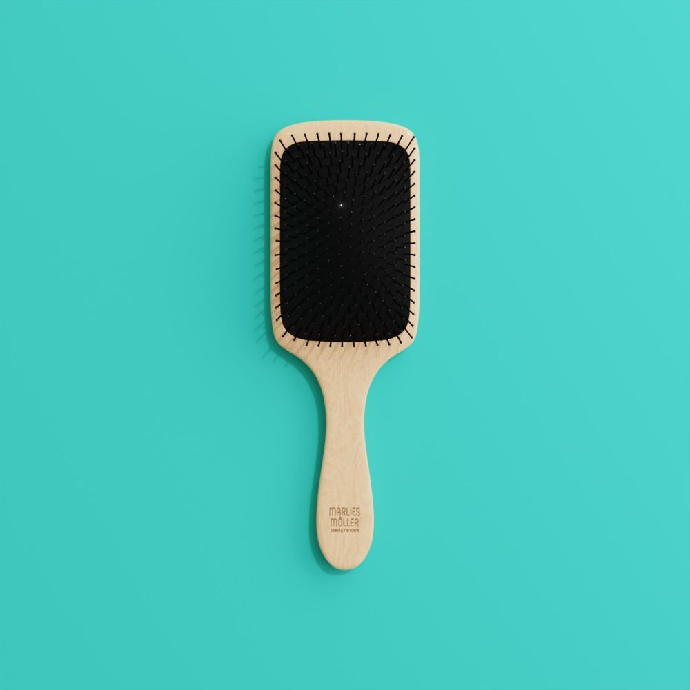 Brosse à cheveux avec manche en bois et coussinet noir, sur fond turquoise.