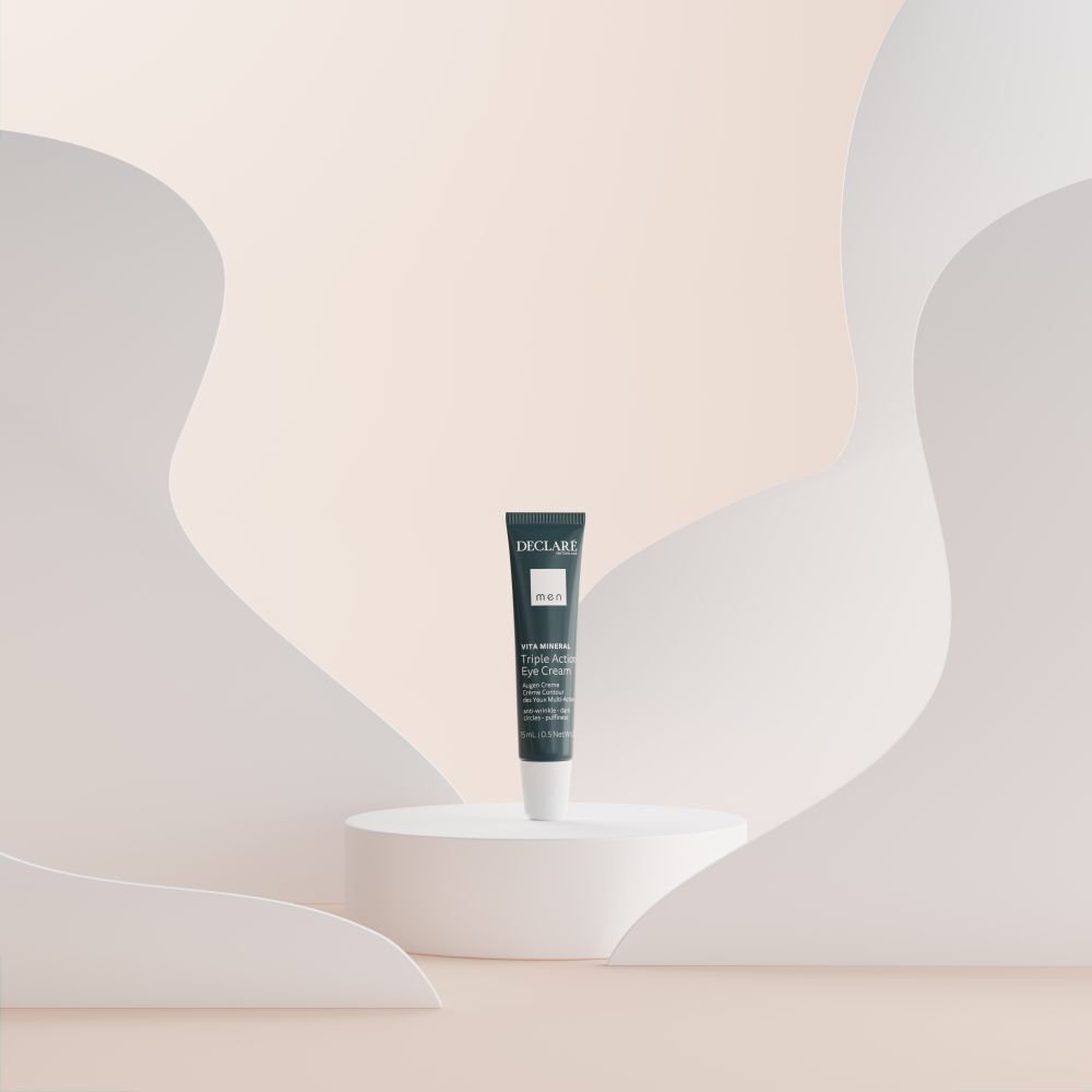 Produktpräsentation. Blaue Tube DECLARÉ Augencreme auf weißem Podest. Hintergrund mit weißen Formen.