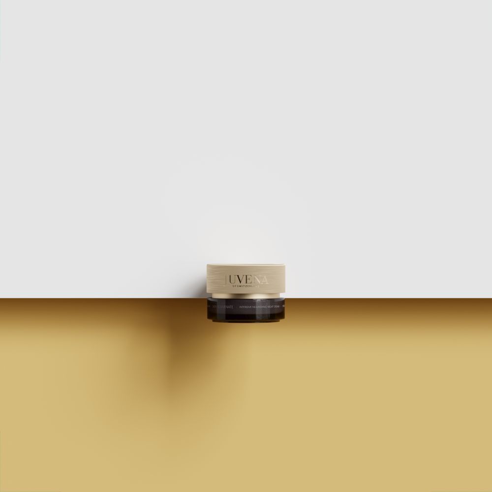 Creme-Dose mit goldenem Deckel. Aufschrift: JUVENA. Auf goldener Oberfläche platziert. Hintergrund: gelb und weiß.