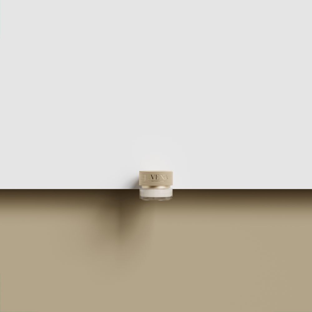 Creme-Glas mit goldfarbenem Deckel. Auf brauner Oberfläche.