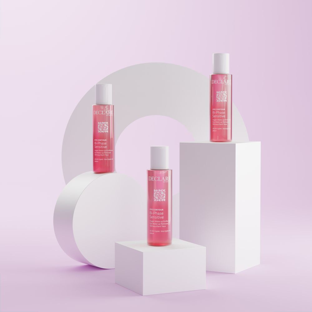 Drei Flaschen. Rosa Flüssigkeit, weiße Kappen. Text: DECLARE, EYE CONTOUR, Bi-Phase Sensitive. Auf weißen Blöcken.