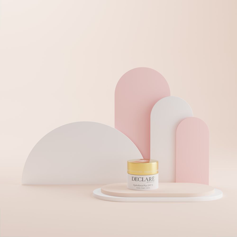 Pot de crème sur socle. Fond : formes abstraites roses et blanches. Inscription : DECLARÉ, Hydroforce Plus SPF15.