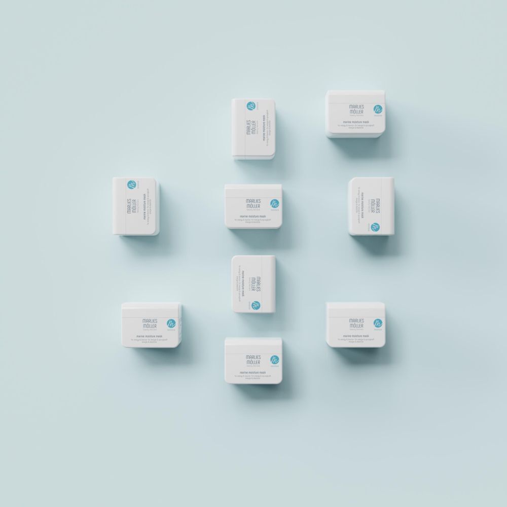 Mehrere weiße Tiegel auf blauem Hintergrund. Marlies Möller Marine Moisture Mask.