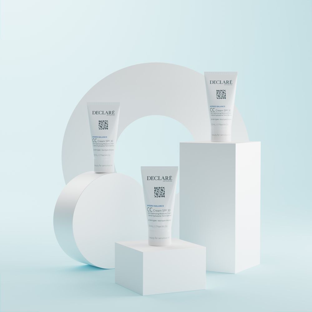 Drei Tuben DECLARÉ CC Cream SPF 30 auf weißen Blöcken. Hintergrund mit weißem Kreis.