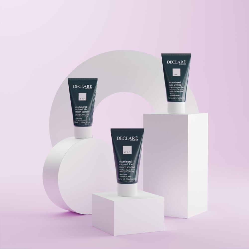 Trois tubes de crème anti-rides Declare sur socles blancs. Fond avec formes géométriques aux tons pastel.