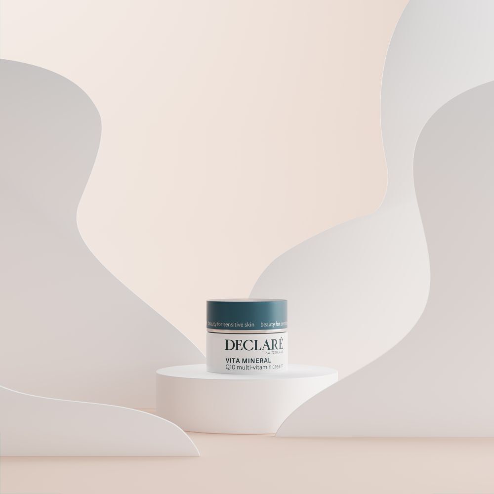 Pot de crème sur socle. DECLARÉ Vita Mineral Q10 Multi-Vitamin Crème. Fond avec formes.