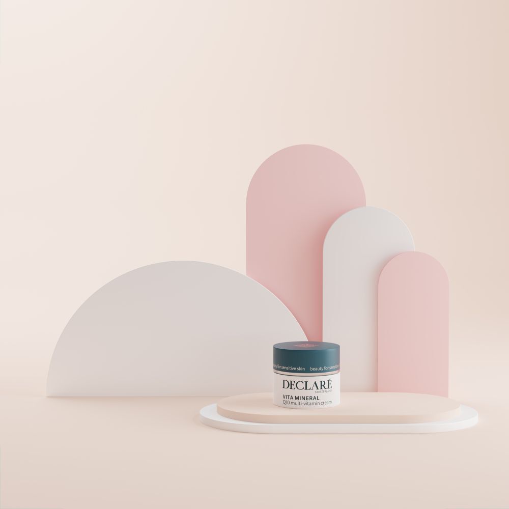 Pot de crème sur socle. DECLARÉ Vita Mineral Q10 Multi-Vitamin Crème. Fond avec formes.