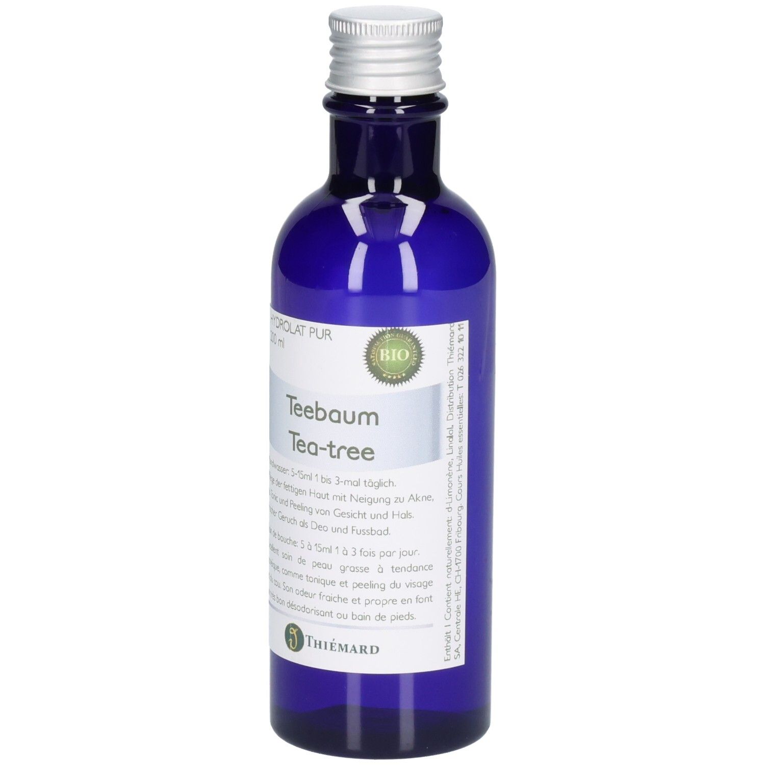 Blaue Glasflasche mit silbernem Verschluss, enthält Teebaumöl. Bio-Siegel und Herstellerlogo sichtbar.