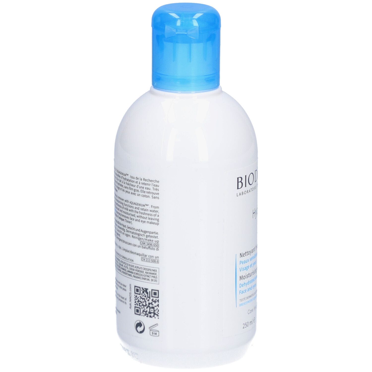 Dos d'un flacon blanc avec bouchon bleu. BIODERMA Hydrabio Lait. Texte multilingue. Code QR et logos.