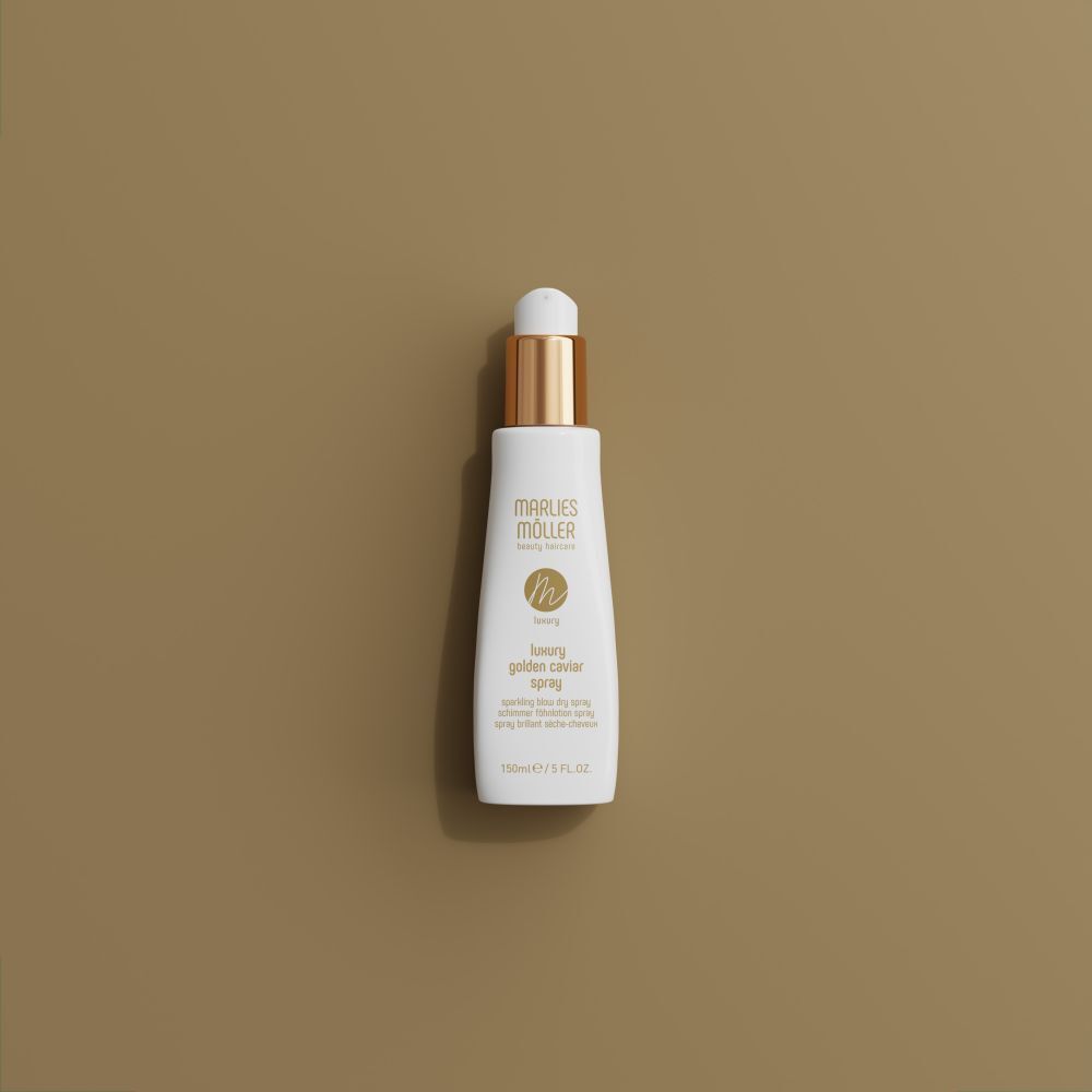 Spray blanc avec bouchon doré sur fond marron. Inscription: Marlies Möller, Luxury Golden Caviar Spray. 150ml/5 FL.OZ.