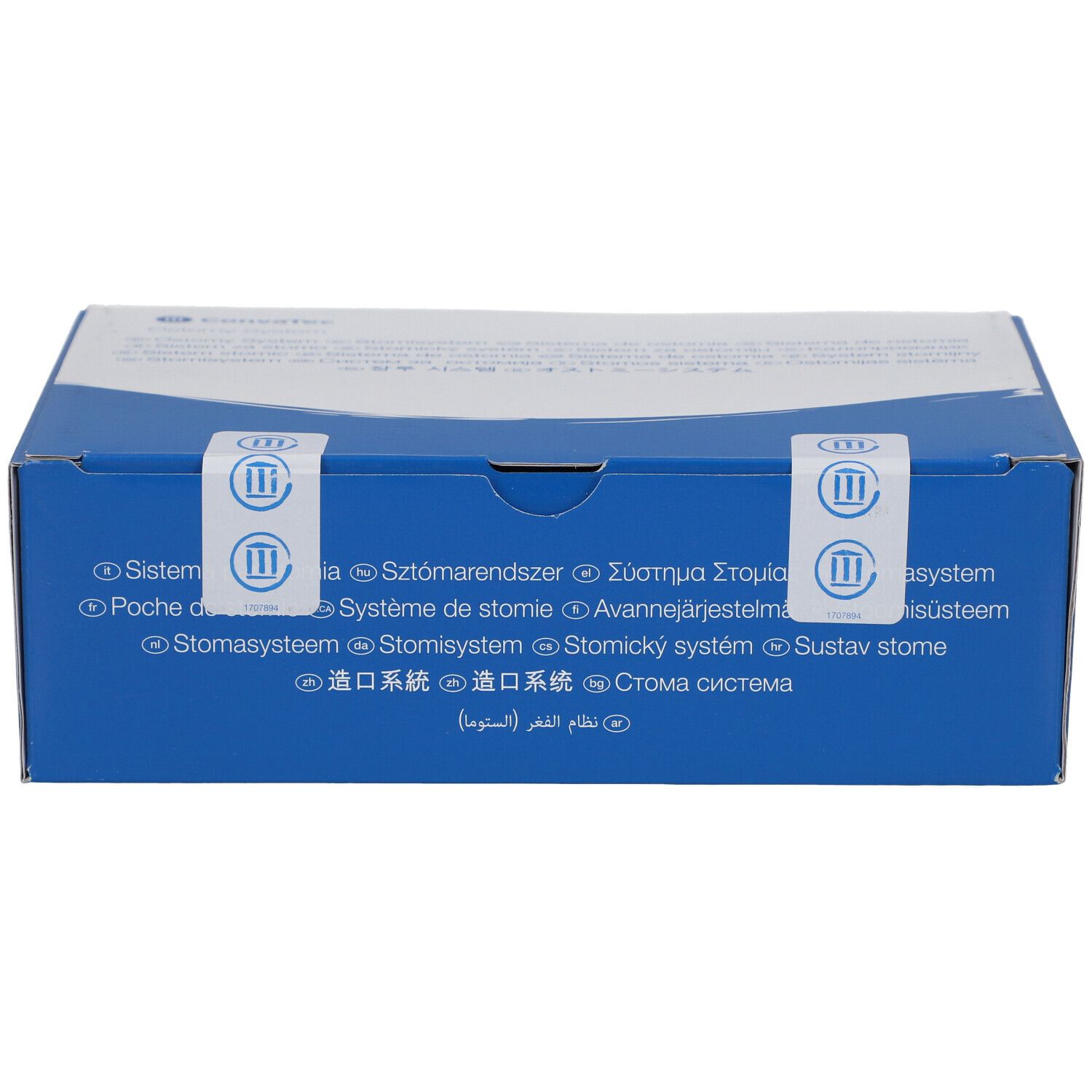 Blaue Schachtel mit weißem Deckel. Aufkleber mit Text in mehreren Sprachen. Siegel mit Logo.