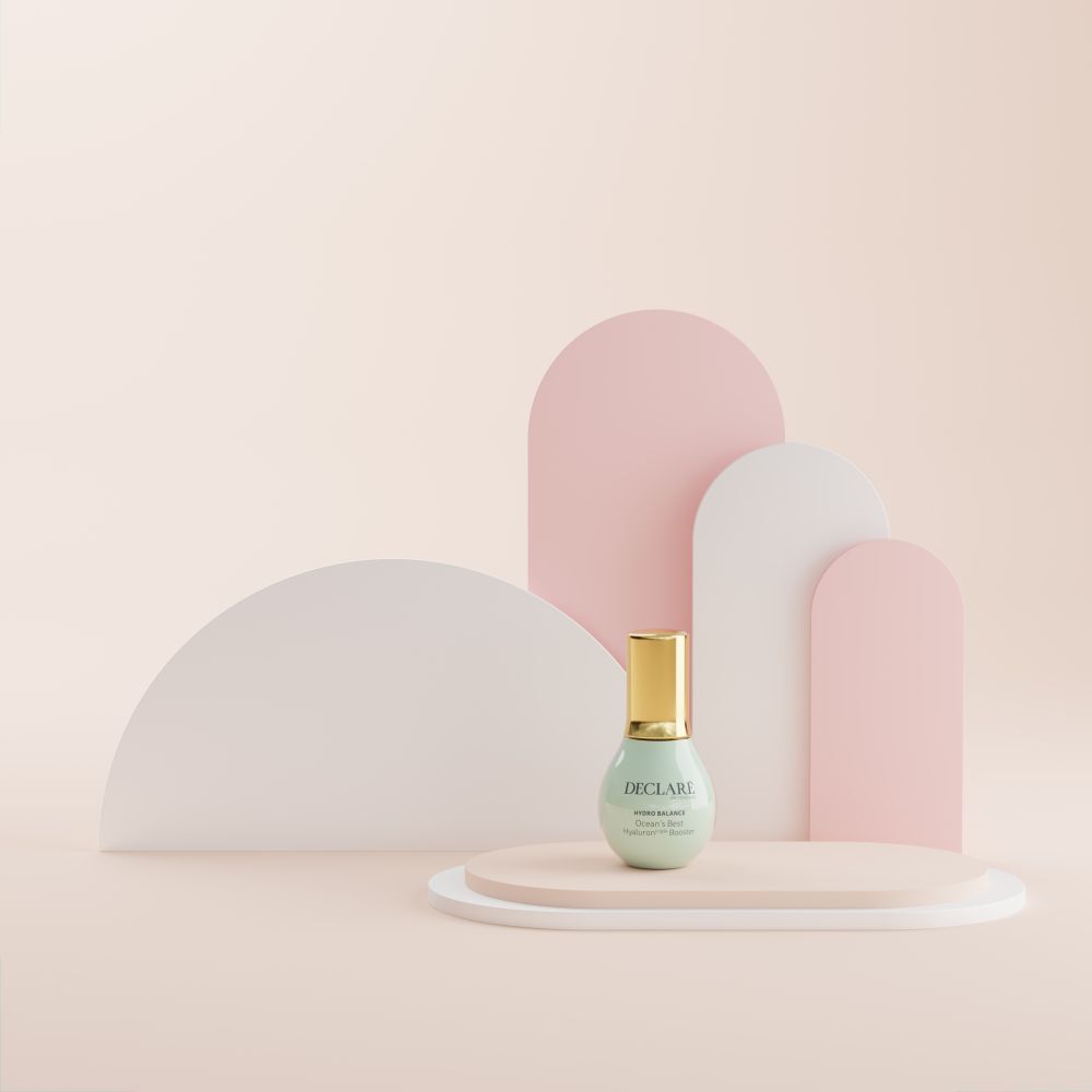 Flacon sur un socle. Fond : formes roses, blanches et roses. Inscription : DECLARÉ, Ocean's Best Hyaluron triple Booster.