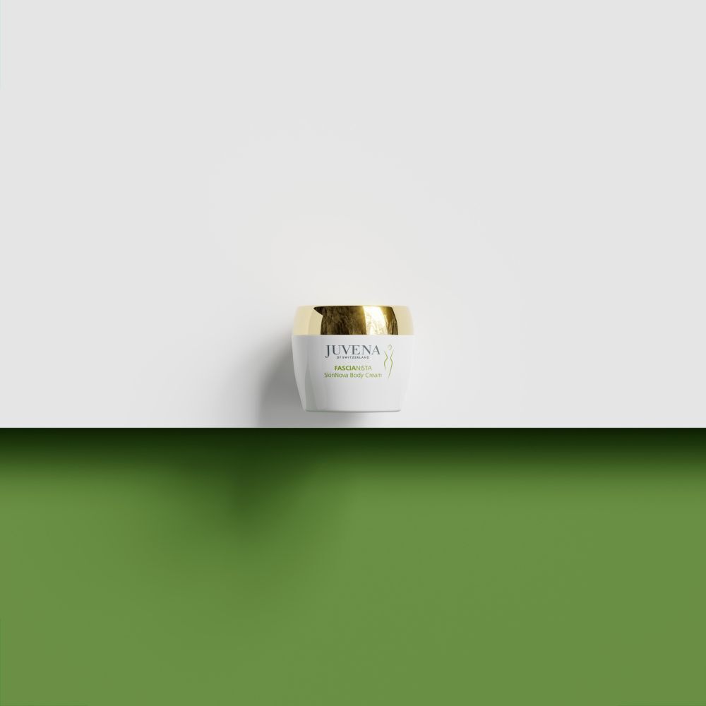 Weißes Cremetiegel mit goldenem Deckel auf grünem Hintergrund. Juvena, Fascionista.