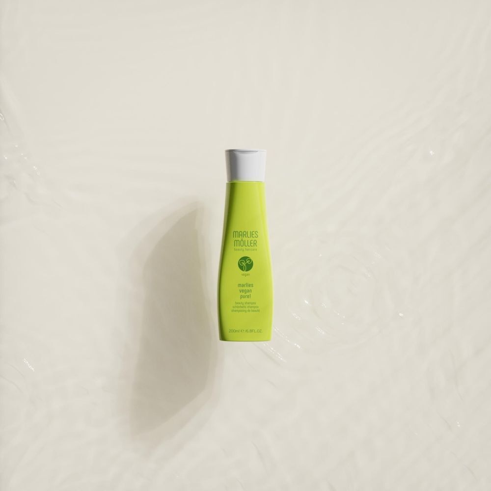 Flacon de shampooing vert dans l'eau. Inscription: Marlies Möller, Vegan Pure! Shampooing.