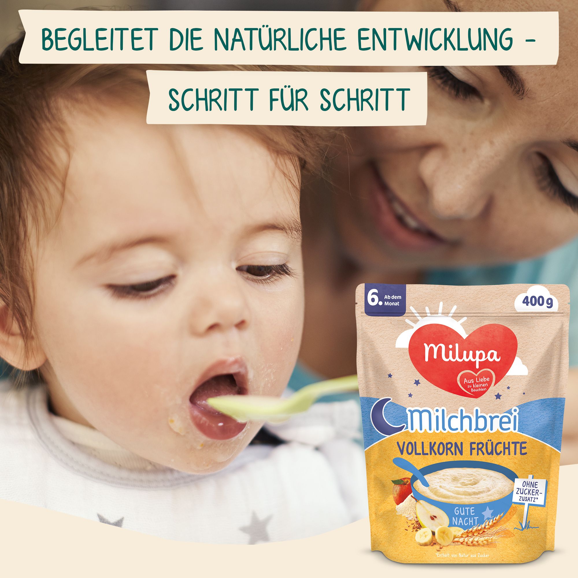 Bébé mange de la bouillie. Maman nourrit bébé à la cuillère. En arrière-plan, emballage Milupa Milchbrei Vollkorn Früchte.