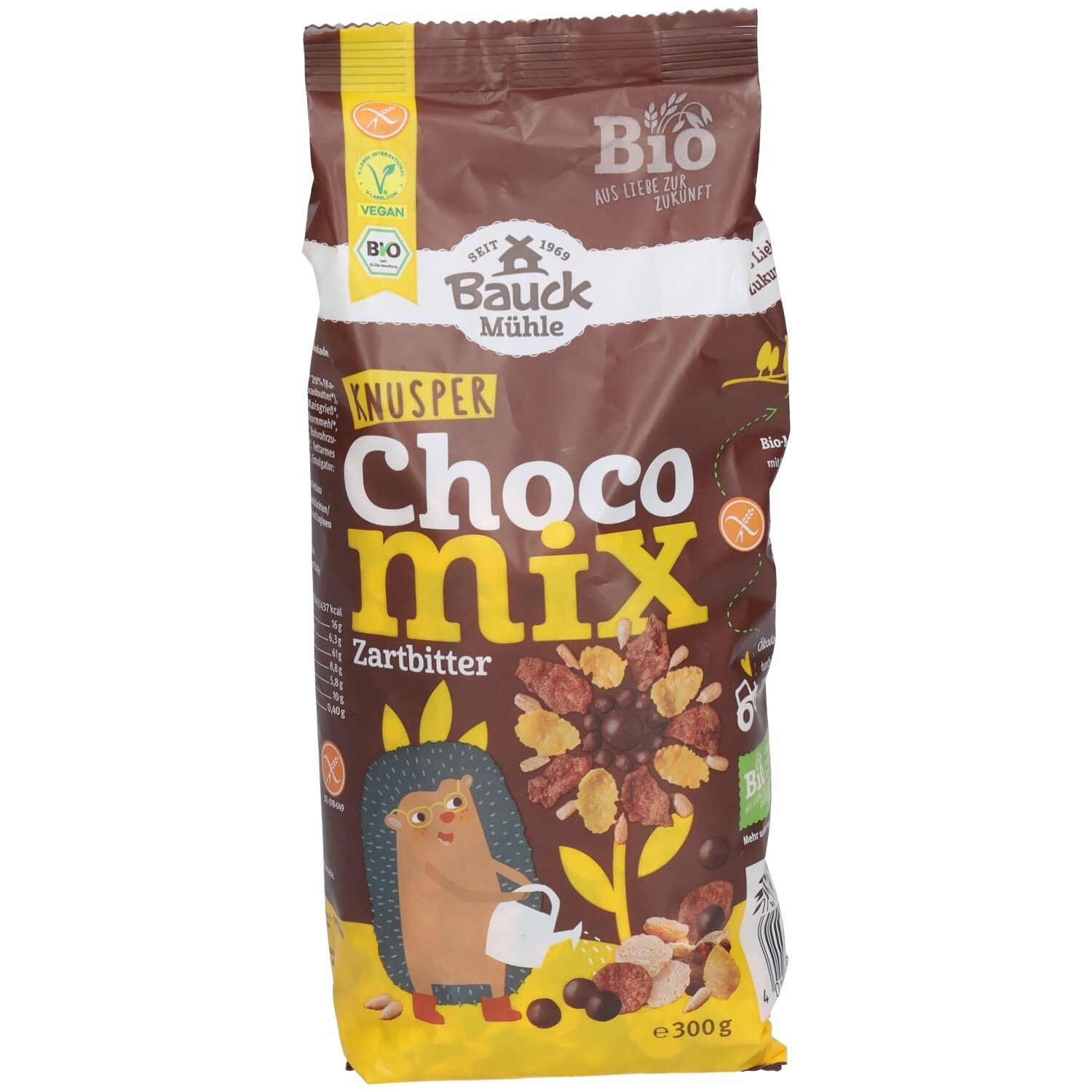 Sachet marron "KNUSPER Choco Mix Zartbitter". Logos vegan et bio. Illustration d'un hérisson et de céréales.