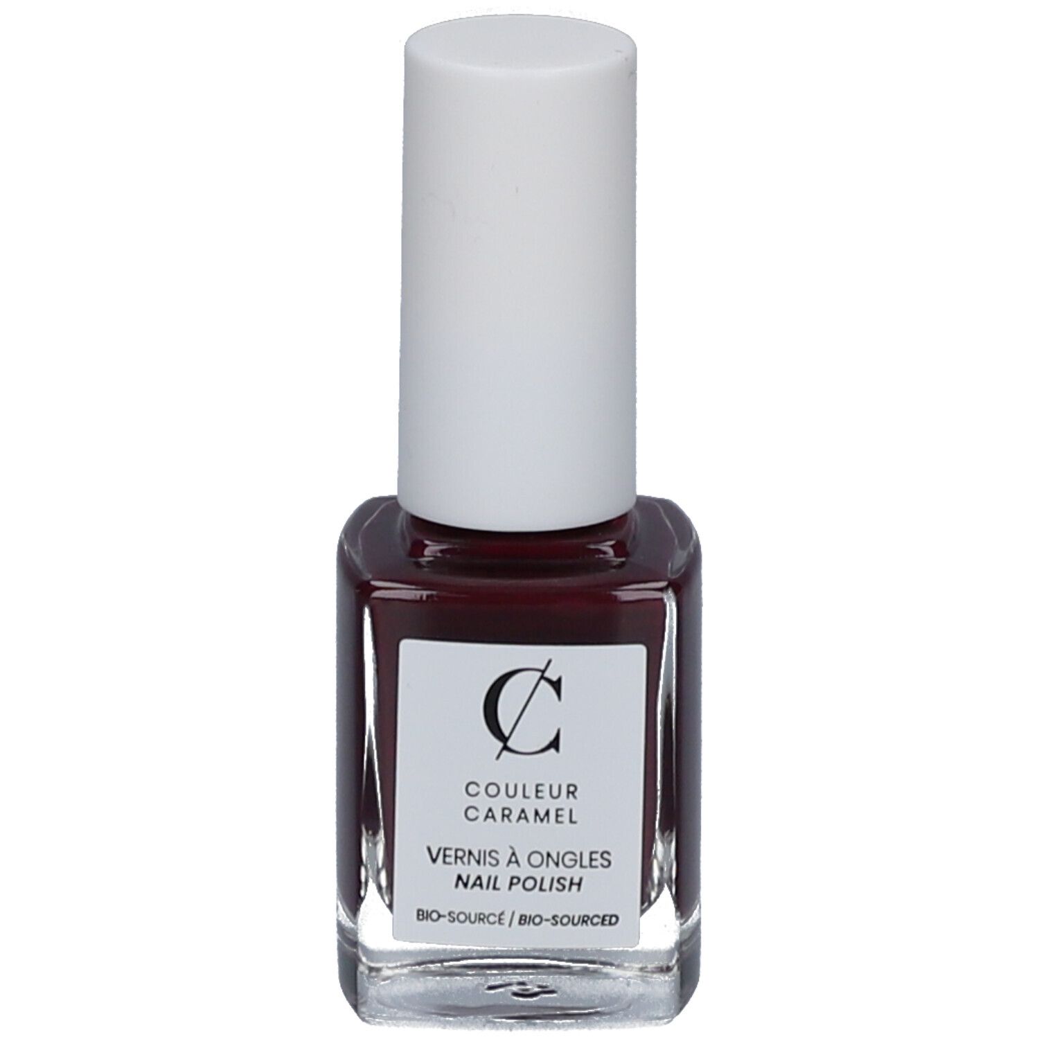 Flacon de vernis à ongles avec bouchon blanc. Étiquette avec logo et texte 'COULEUR CARAMEL'. Vernis rouge foncé.