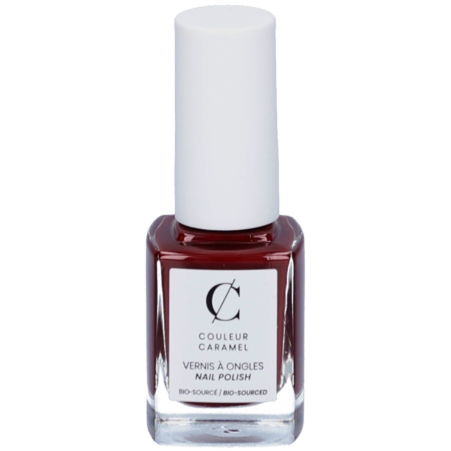 Flacon de vernis à ongles rouge-brun. Bouchon blanc. Étiquette avec logo et texte COULEUR CARAMEL, Vernis à ongles, Nail Polish.