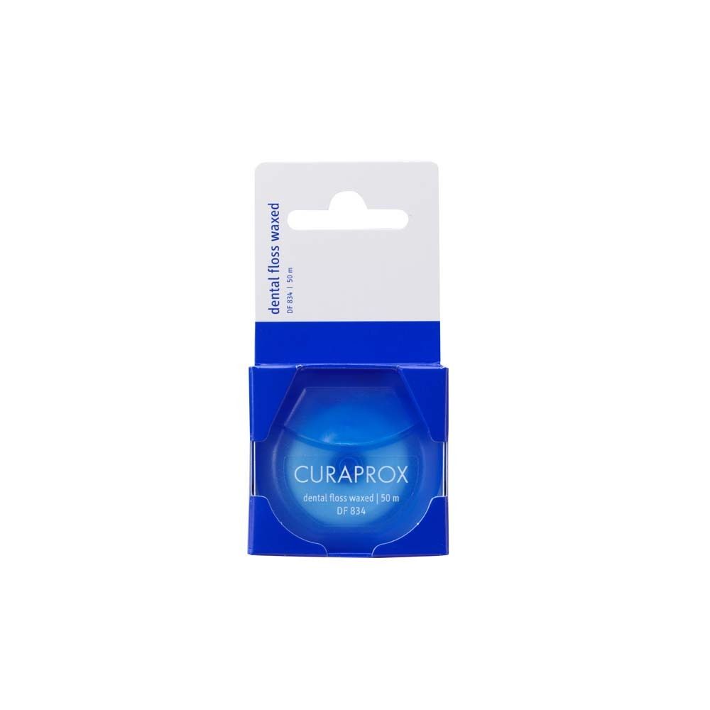 Bobine de fil dentaire bleu dans emballage. Marque CURAPROX, texte "dental floss waxed".