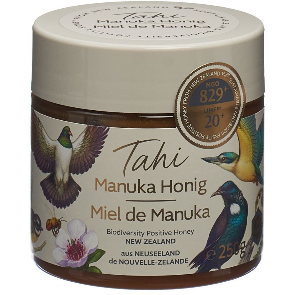 Glas mit Honig. Aufschrift: Tahi Manuka Honig, Miel de Manuka. Mit Zertifikat UMF 20+ MGO 829+. Abbildung von Vögeln.