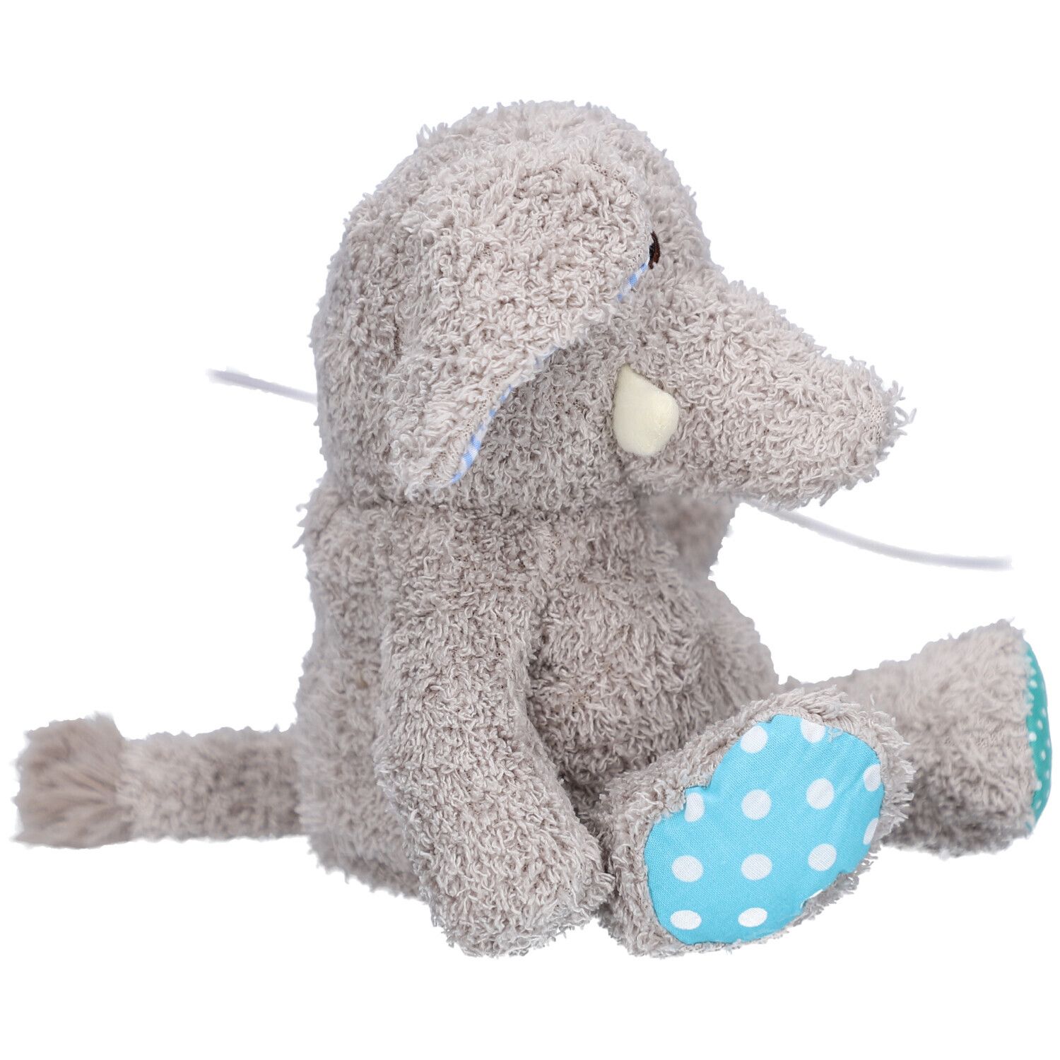 Éléphant en peluche gris assis, avec pois bleus sur les pieds. Défense blanche visible.