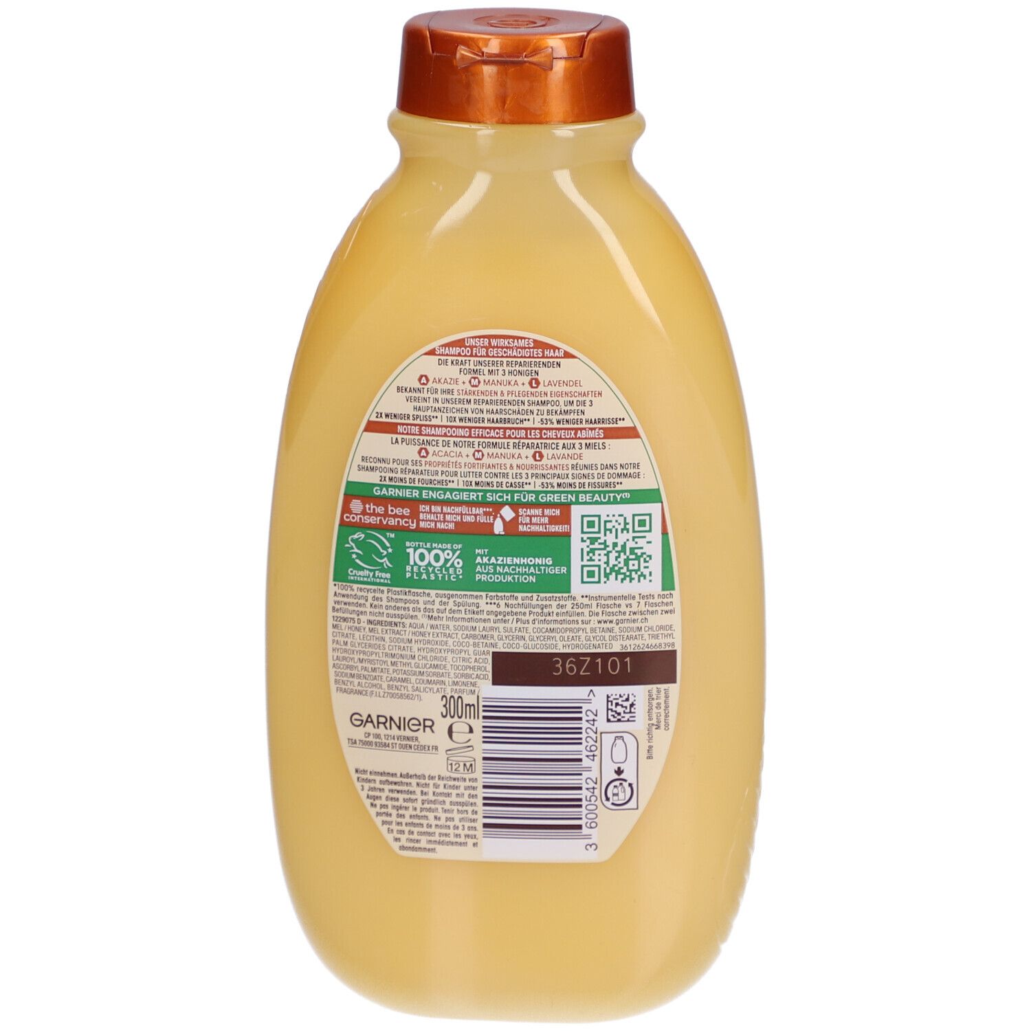 Dos du flacon de shampooing Garnier Ultra Doux. Flacon jaune avec bouchon marron. Texte et code QR sur l'étiquette.