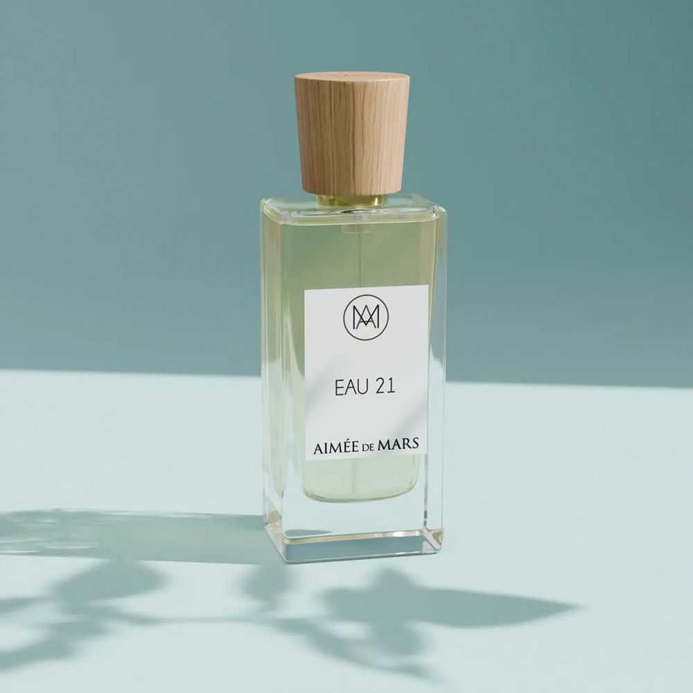 Aimée de Mars Eau 21 Eau de Parfum. Glasflakon mit Holzverschluss. Weißes Etikett mit Logo und Produktbezeichnung.