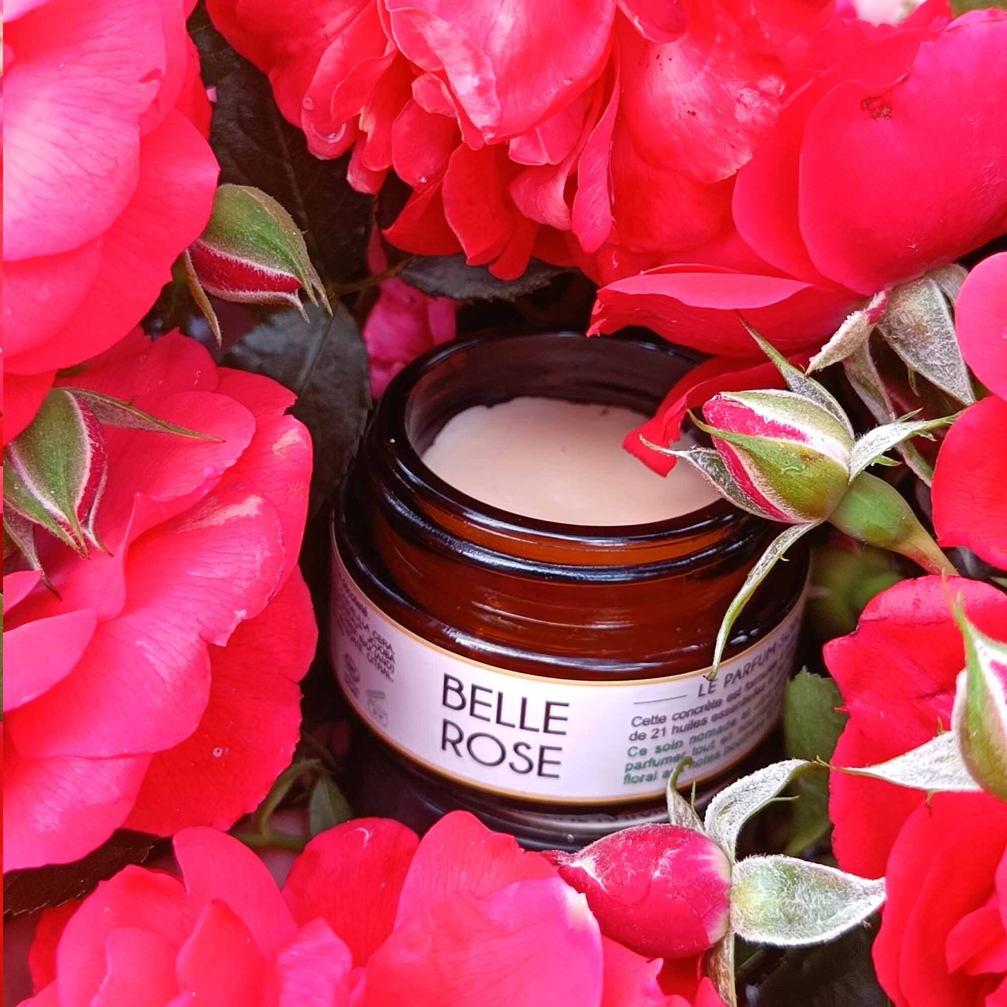 Petit pot avec étiquette "Belle Rose", entouré de pétales de roses rouges. Le contenu du pot est visible.