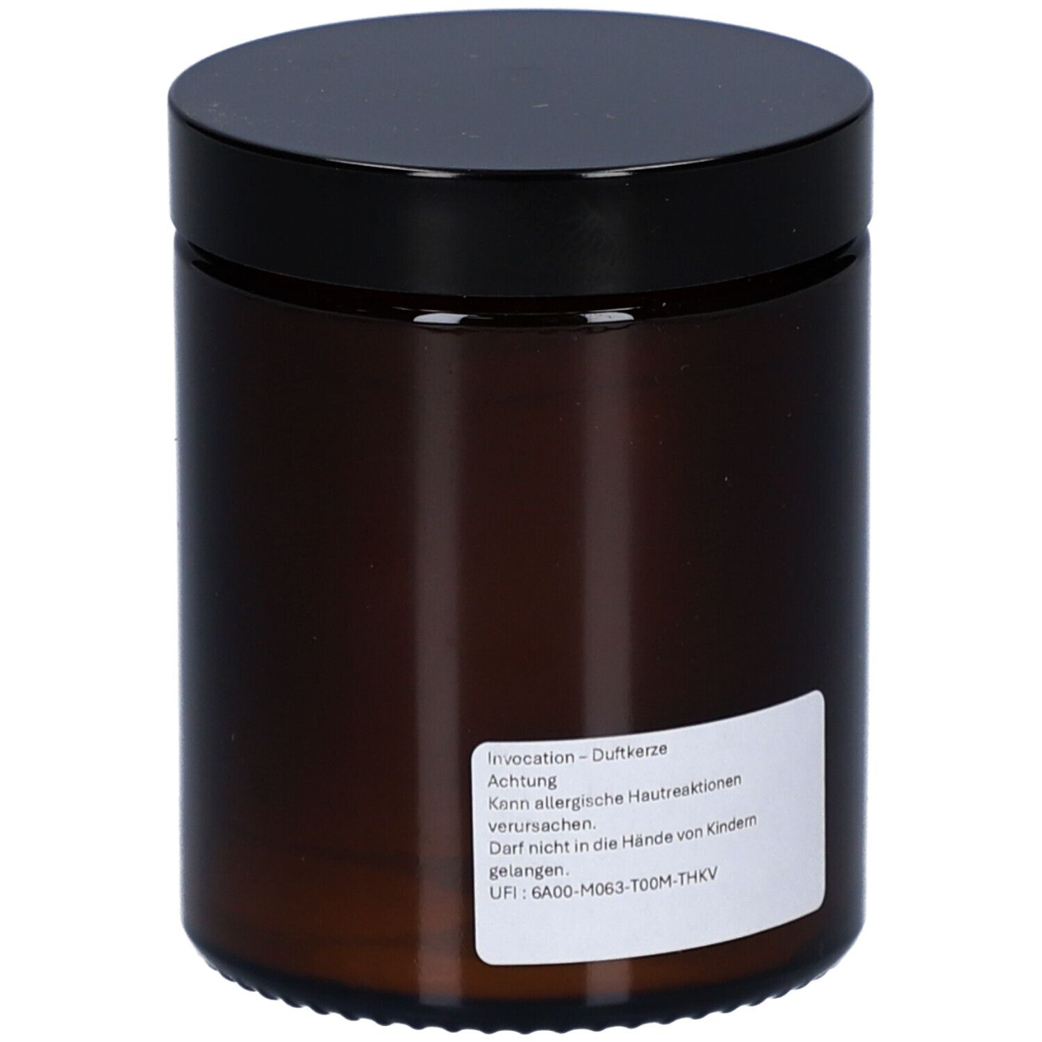 Bougie marron avec couvercle noir. Autocollant avec texte. Avertissements.