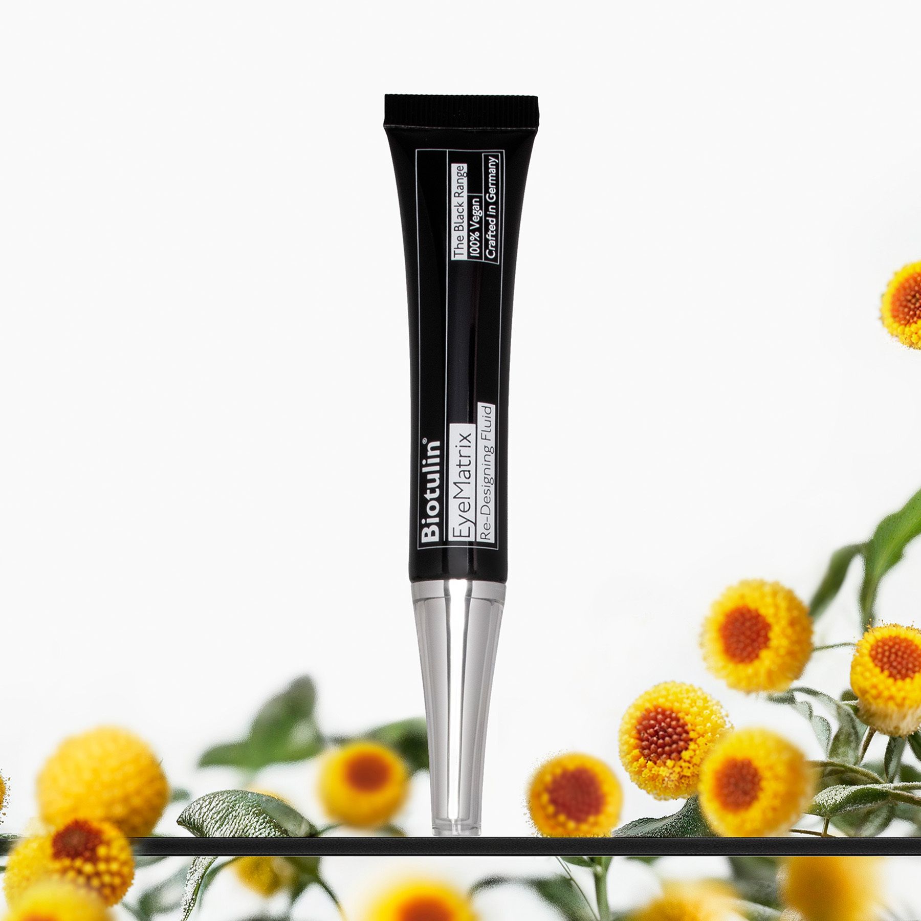 Tube noir avec embout argenté, entouré de fleurs. Texte : Biotulin EyeMatrix Re-Designing Fluid.