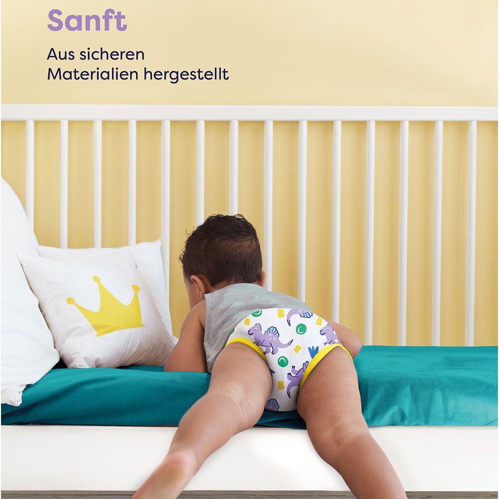 Kind in Lernhöschen auf dem Boden. Text: Sanft. Aus sicheren Materialien hergestellt.