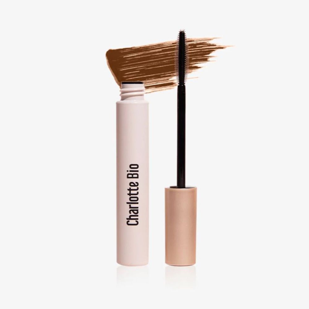 Braune Mascara mit Bürste und Farbabstrich. Aufschrift Charlotte Bio auf der Tube. Helle Verpackung.