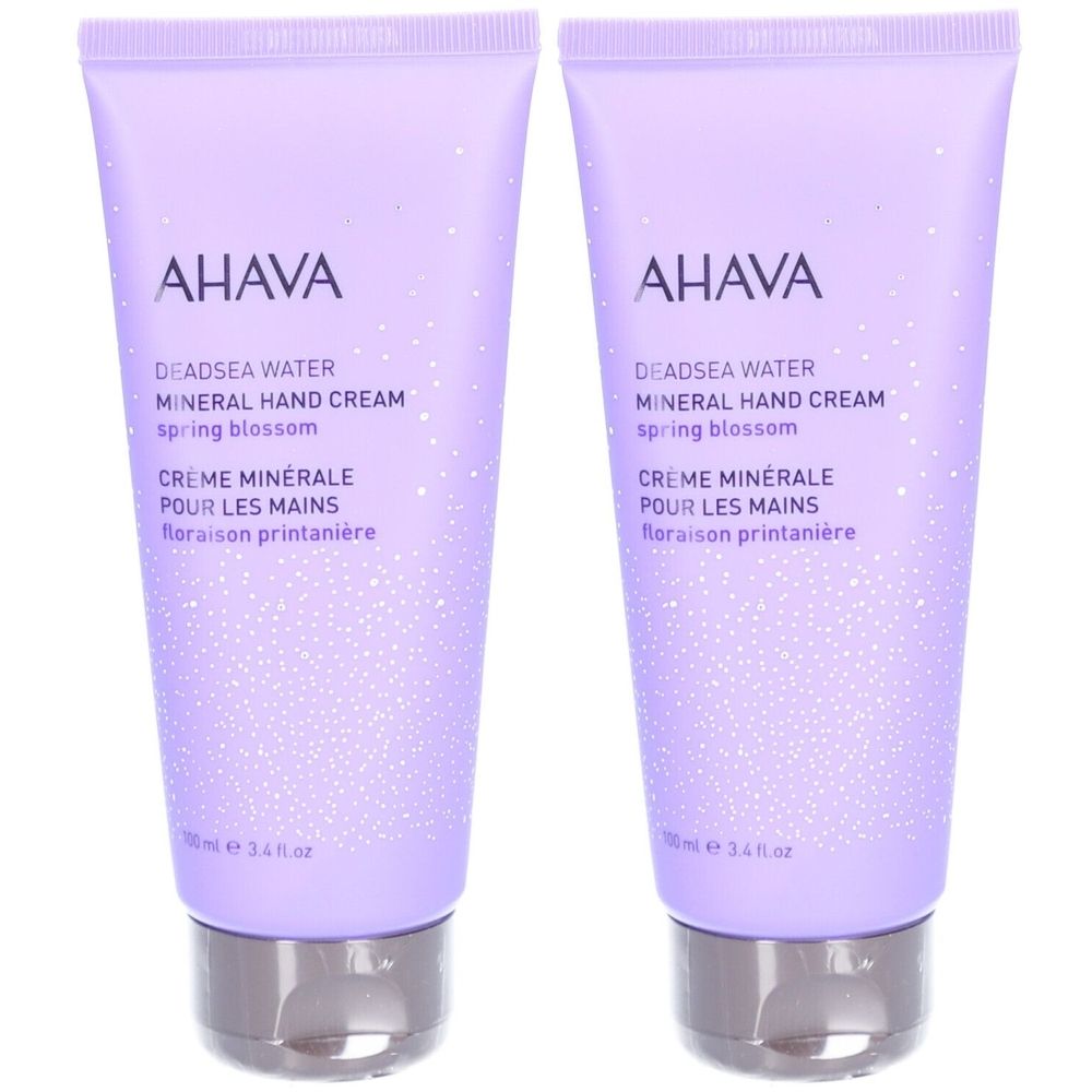 Deux tubes de crème pour les mains AHAVA. Emballage lilas avec bouchon argenté. Texte: Deadsea Water, Mineral Hand Cream, Crème Minérale.