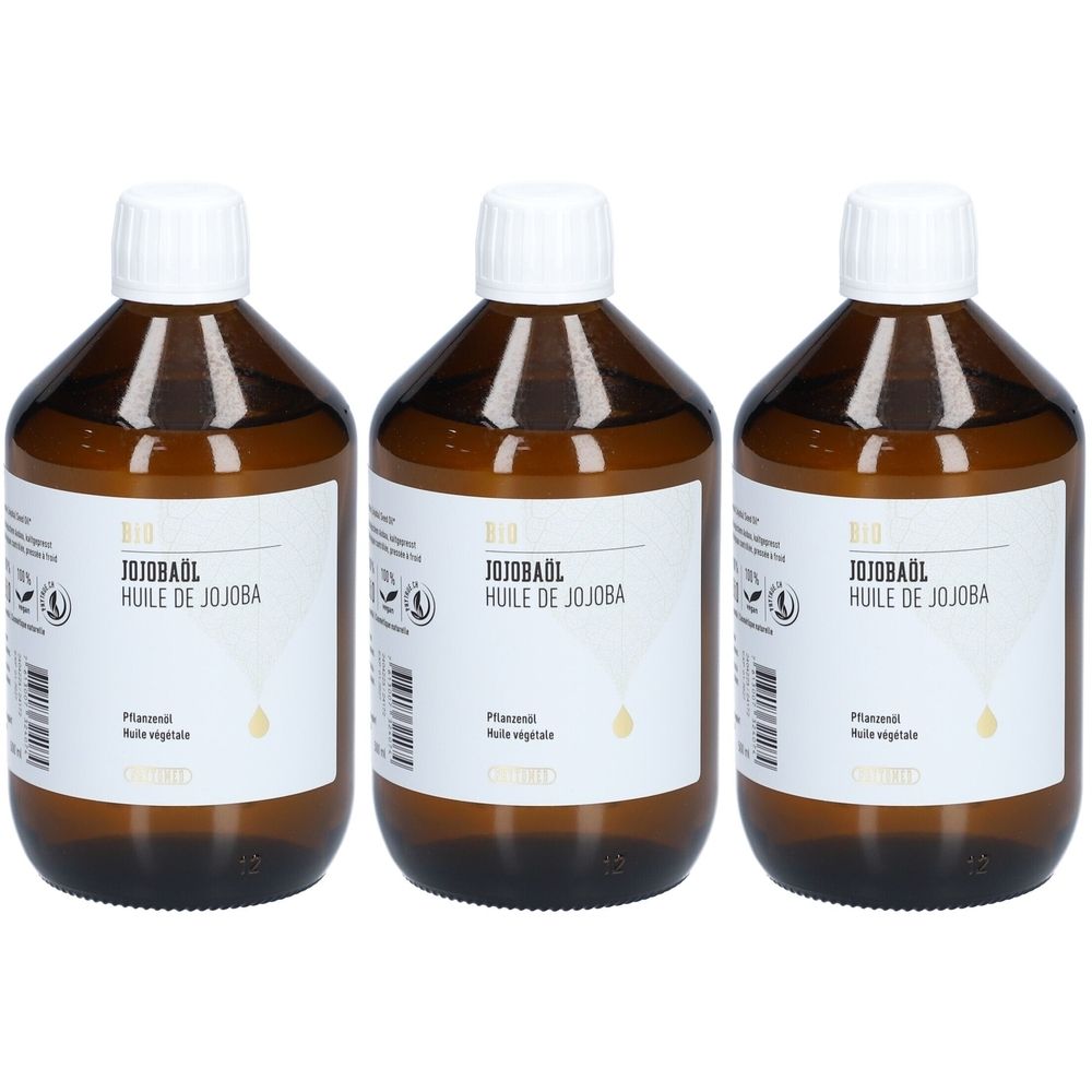 Trois flacons en verre brun avec bouchon blanc et étiquette. L'étiquette indique "Huile de Jojoba" en allemand et français. Le produit est de "PHYTOMED".