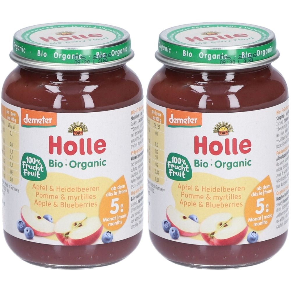 Deux pots de nourriture pour bébés. Inscription : Holle Bio-Organic, Pomme & myrtilles. Avec le sceau Demeter. Couvercle vert avec inscription.