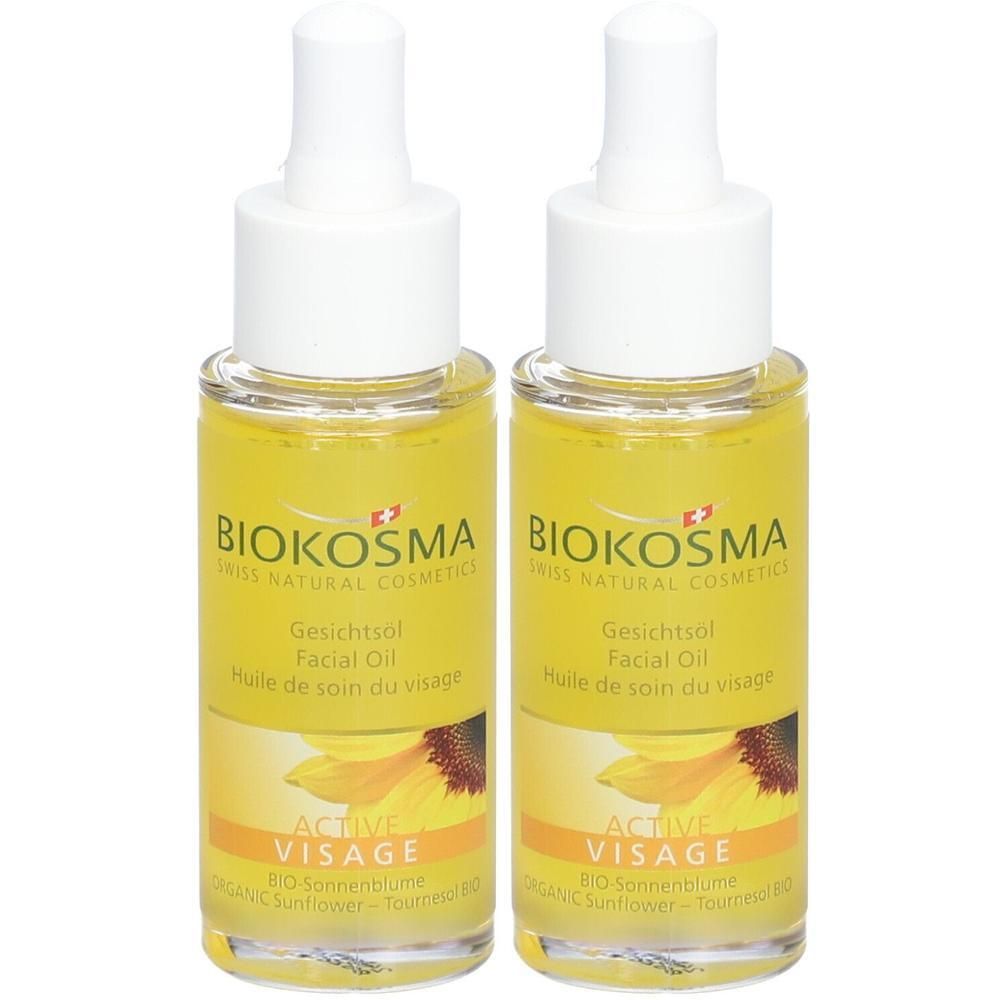 Deux flacons d'huile pour le visage avec liquide jaune, bouchon blanc et étiquette avec logo et tournesol.