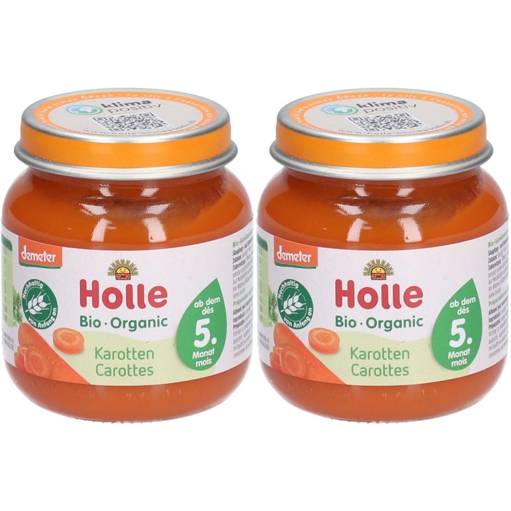 Zwei Gläser Holle Bio-Organic Karotten-Babynahrung. Gläser mit orangefarbenem Inhalt, Deckel und Etiketten. Demeter-Siegel.