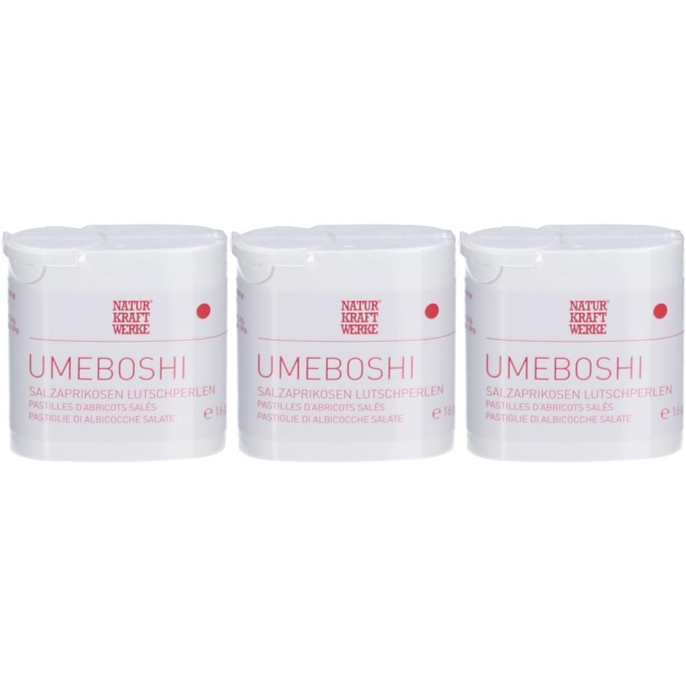 Drei weiße Behälter mit Deckel. Aufschrift UMEBOSHI, NATURKRAFTWERKE. Rote Punkte und Text in mehreren Sprachen.