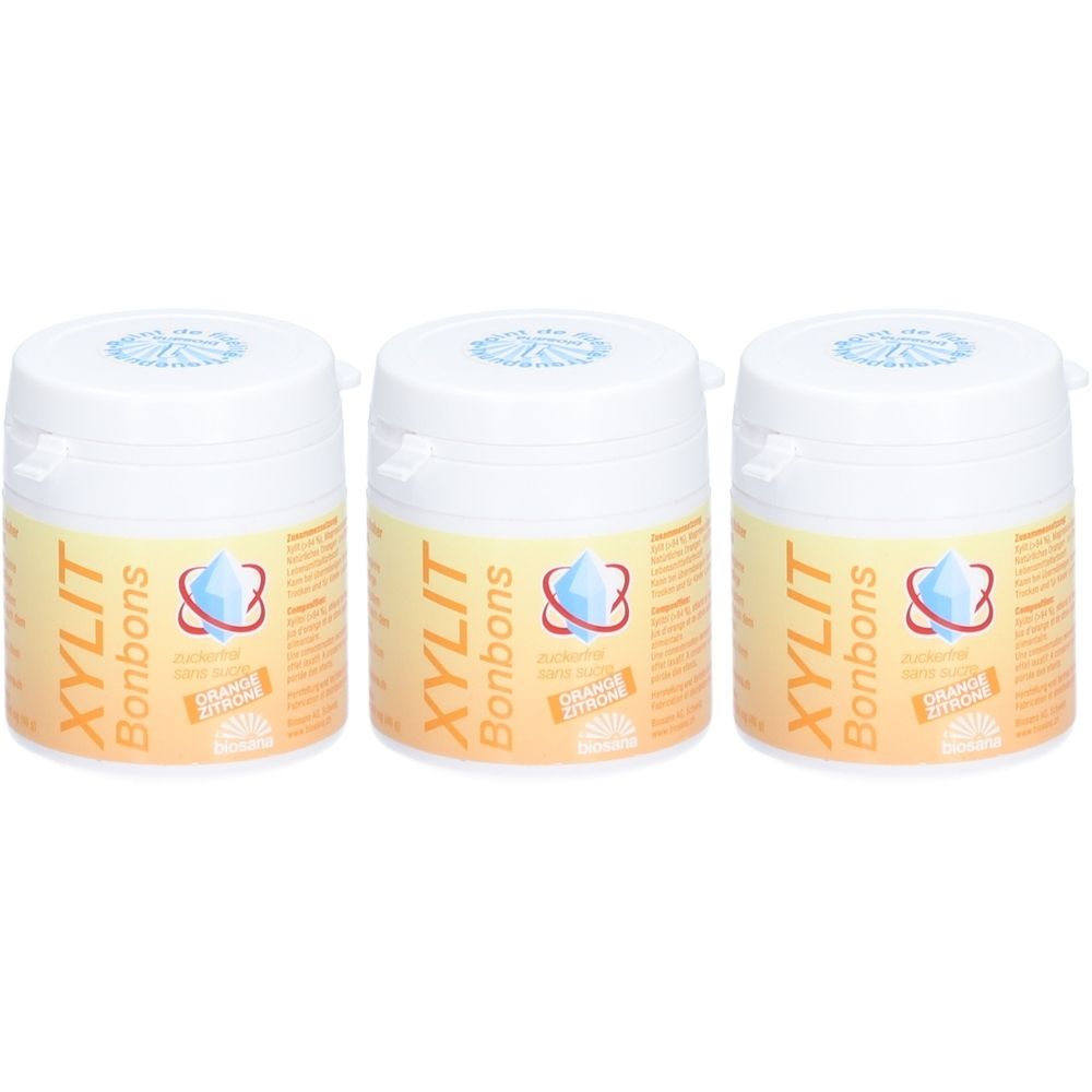 Drei weiße Dosen mit Deckel. Auf jeder Dose steht "XYLIT Bonbons" und ein Logo. Aufkleber mit "Orange Zitrone".
