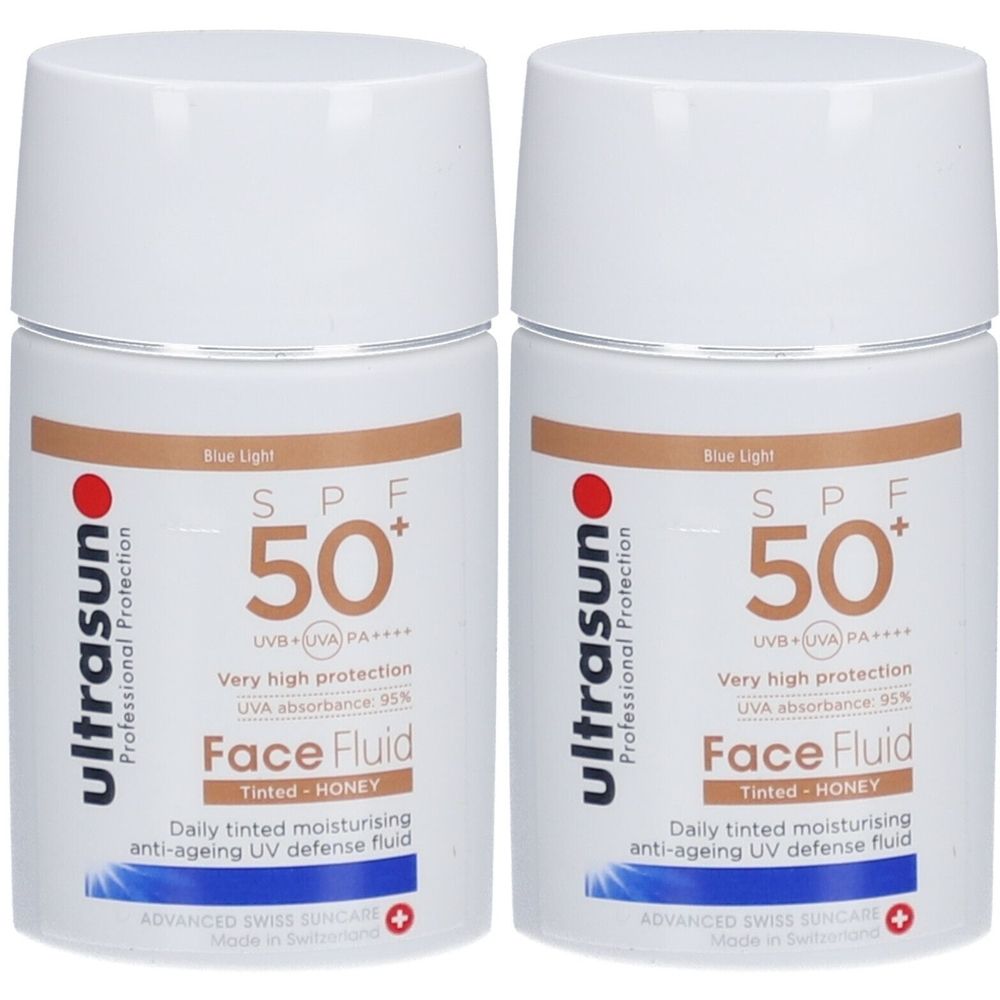 Deux flacons blancs avec bouchons blancs. Inscription : ultrasun, SPF 50+, Face Fluid, teinté, Honey. Protection UV anti-âge.