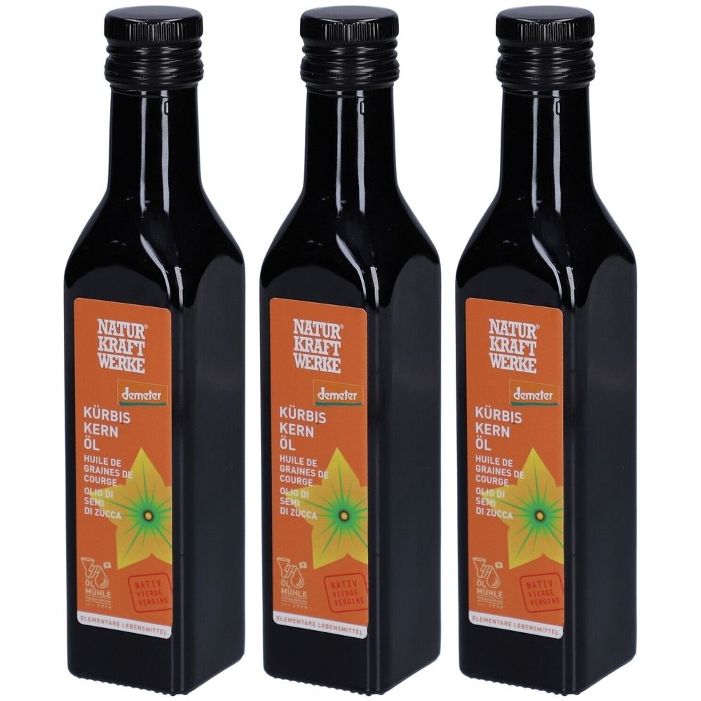 Drei Flaschen Kürbiskernöl. Schwarze Flaschen mit Etikett. Aufschrift: NATUR KRAFT WERKE, KÜRBIS KERN ÖL, Demeter-Siegel.